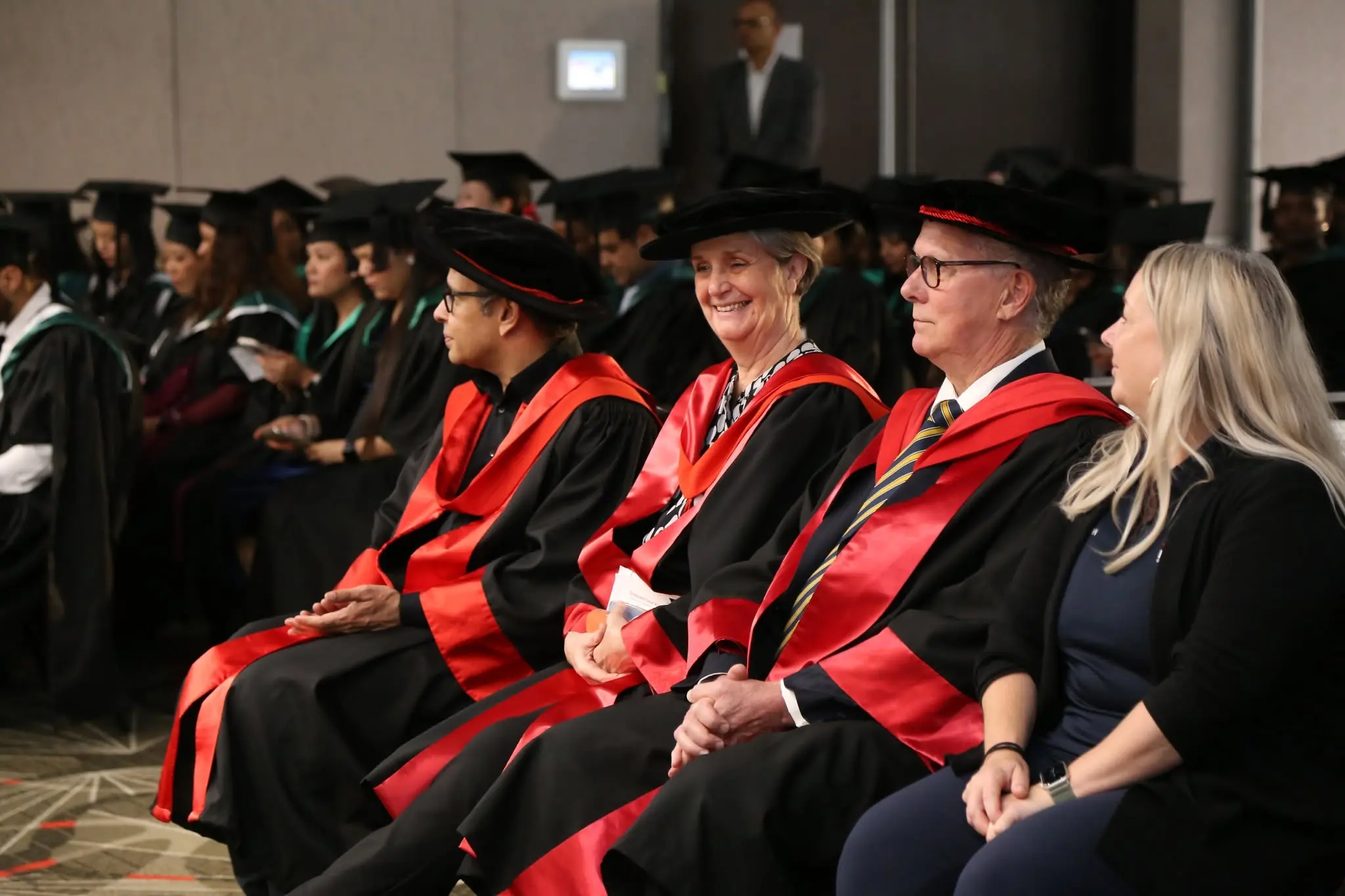 IHM graduate portrait beside ceremony curtain