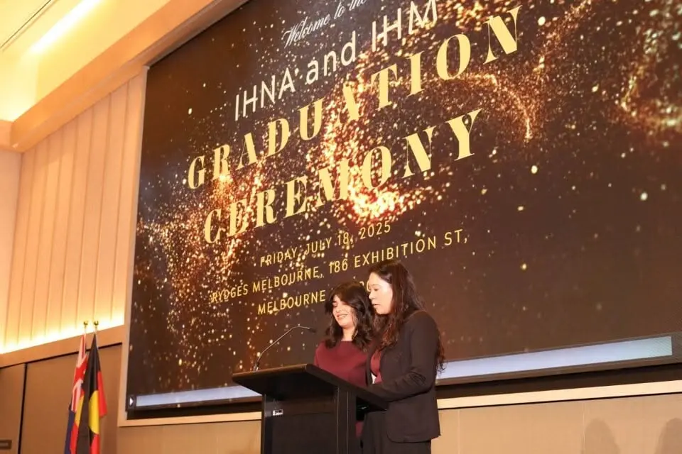 IHM alumni graduation portrait on stage