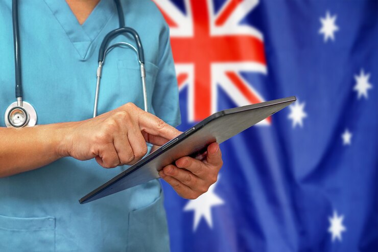 nurse-using-digital-tablet-background-australia-flag